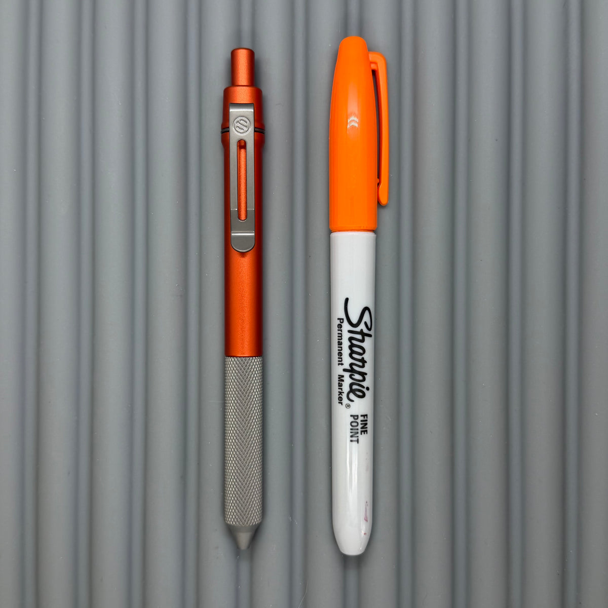 > Spoke Click Model C: Orange Lava Aluminum / Matte Titanium Peak Knurled Grip