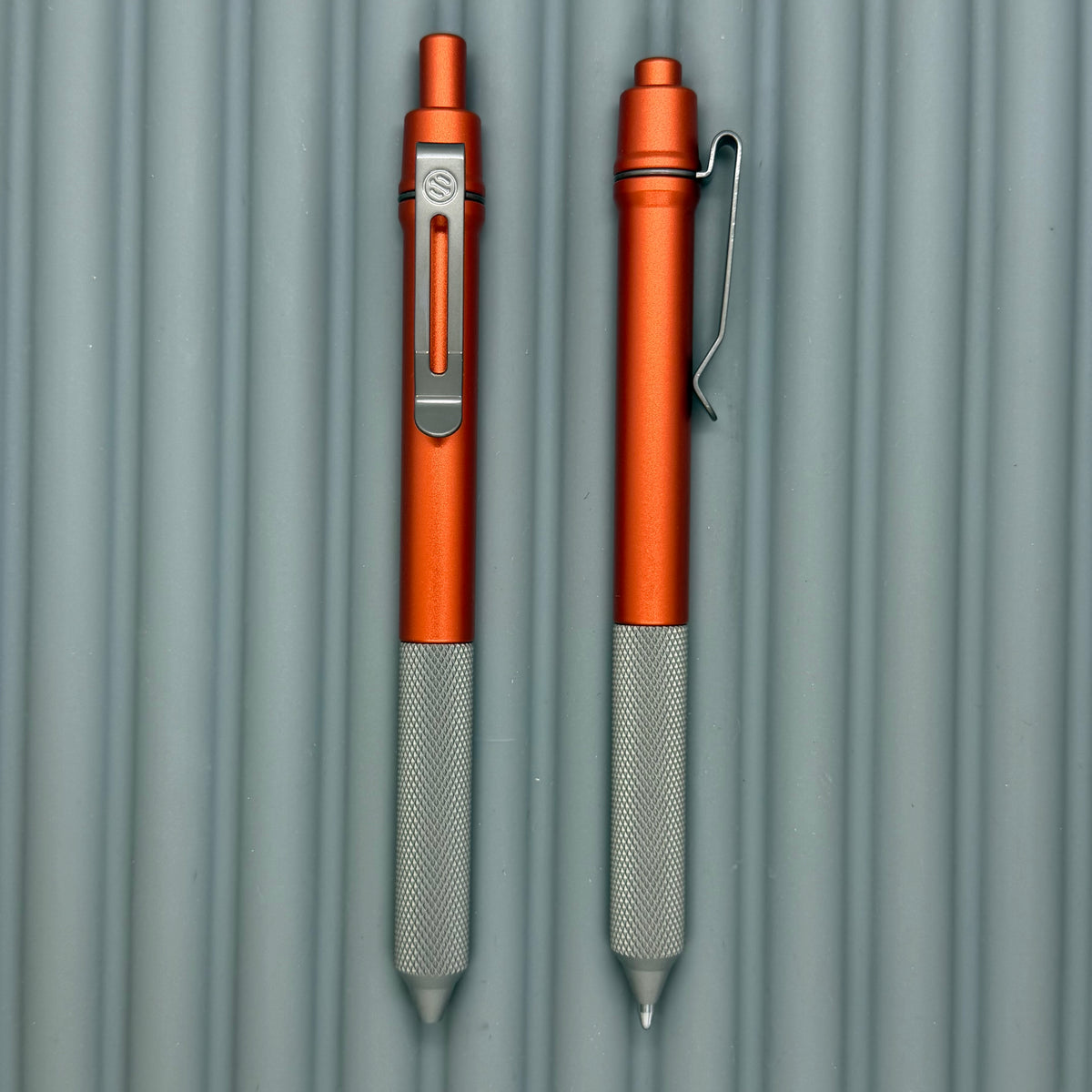 > Spoke Click Model C: Orange Lava Aluminum / Matte Titanium Peak Knurled Grip