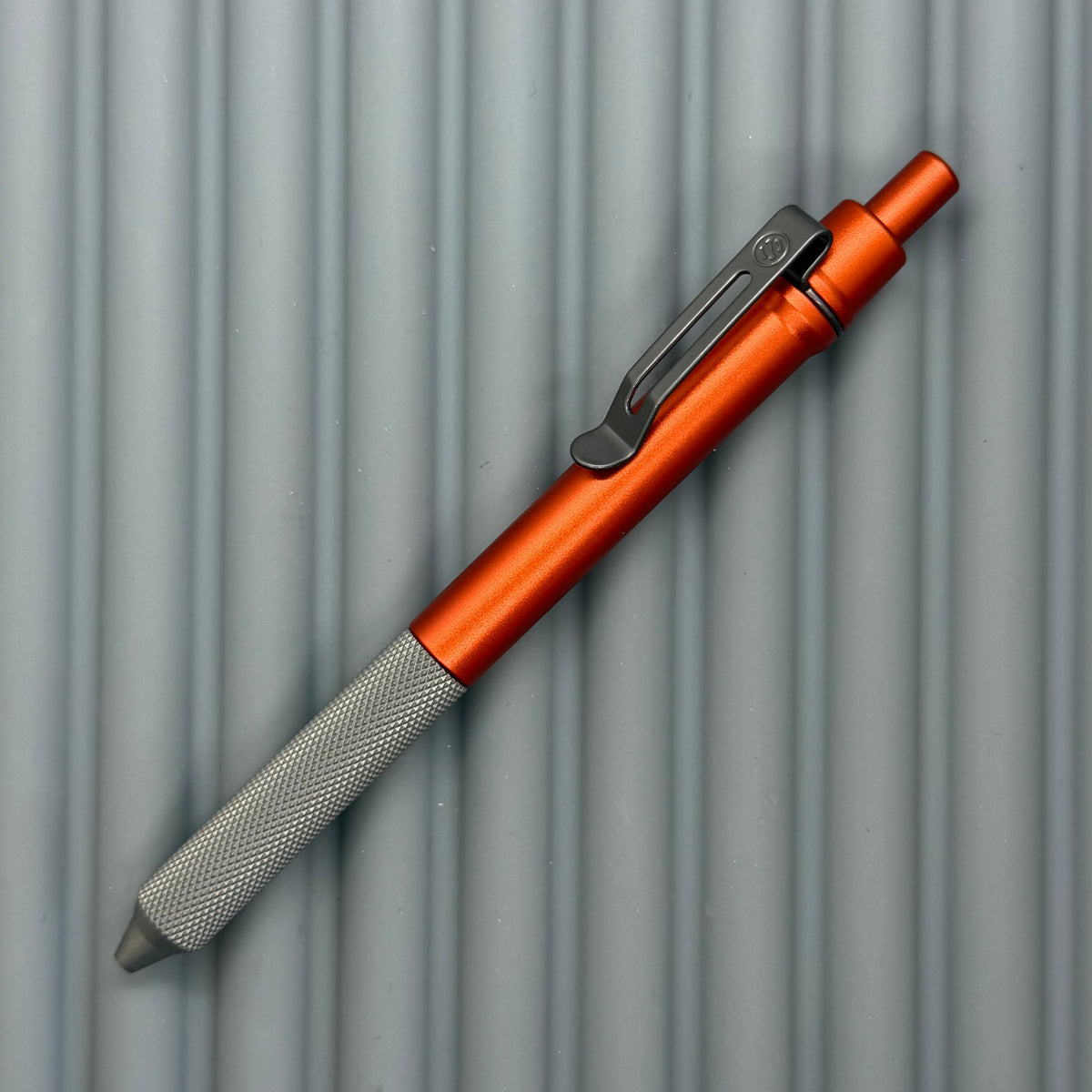 > Spoke Click Model C: Orange Lava Aluminum / Matte Titanium Peak Knurled Grip