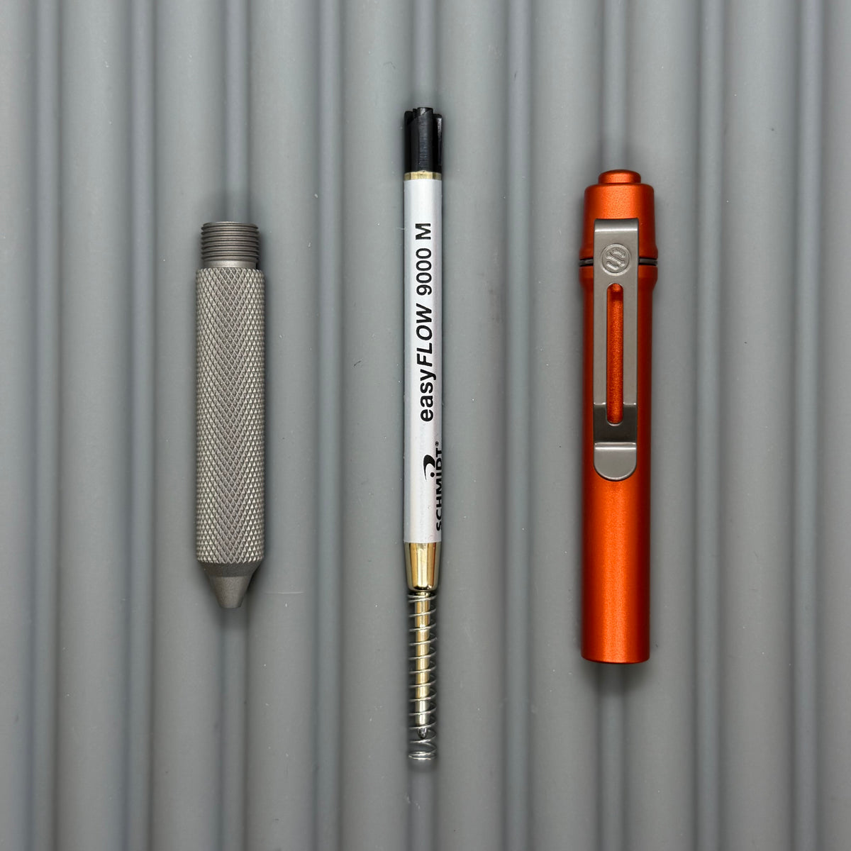 > Spoke Click Model C: Orange Lava Aluminum / Matte Titanium Peak Knurled Grip