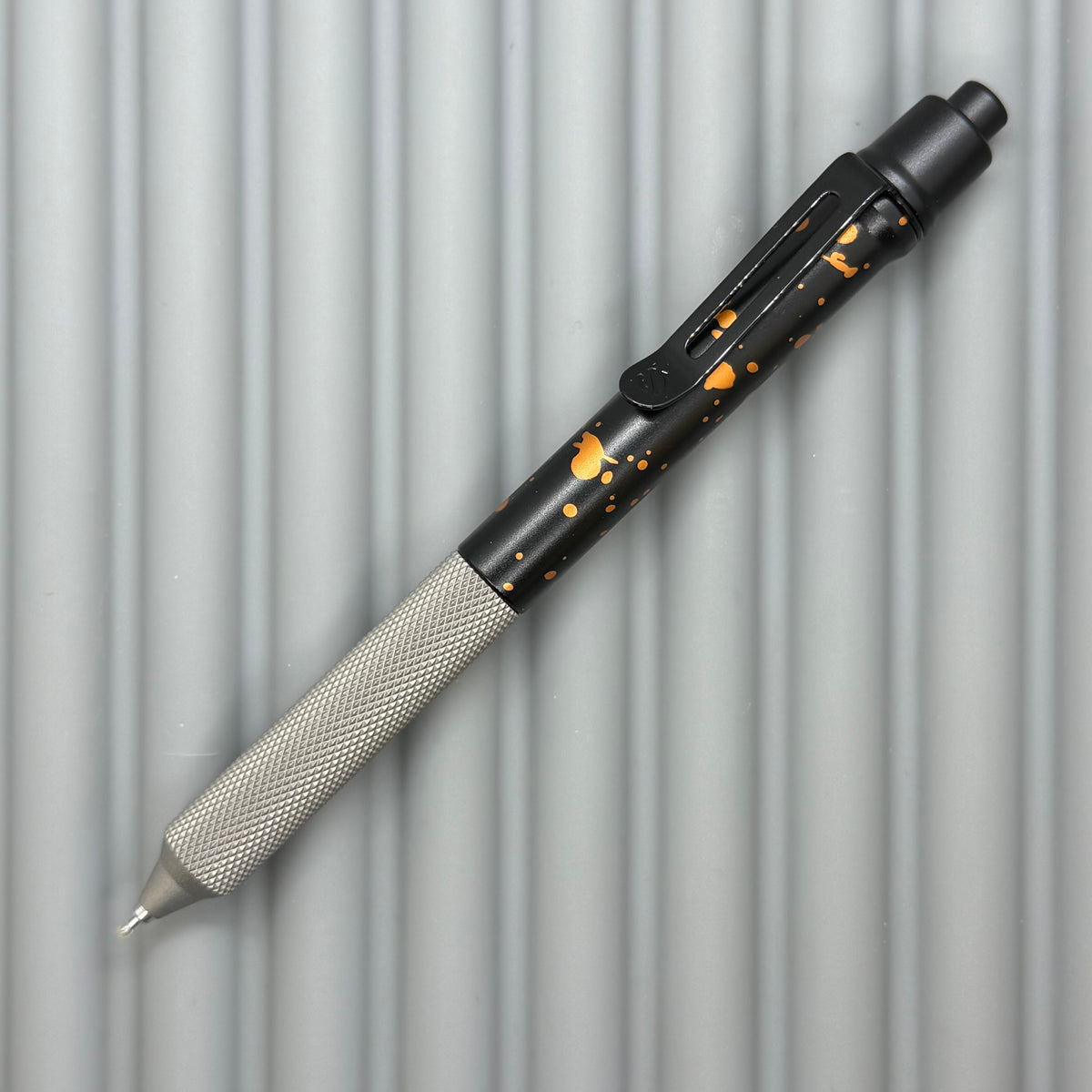 > Spoke Click Model C: Black with Orange Lava Splash, Aluminum / Matte Titanium Peak Knurled Grip