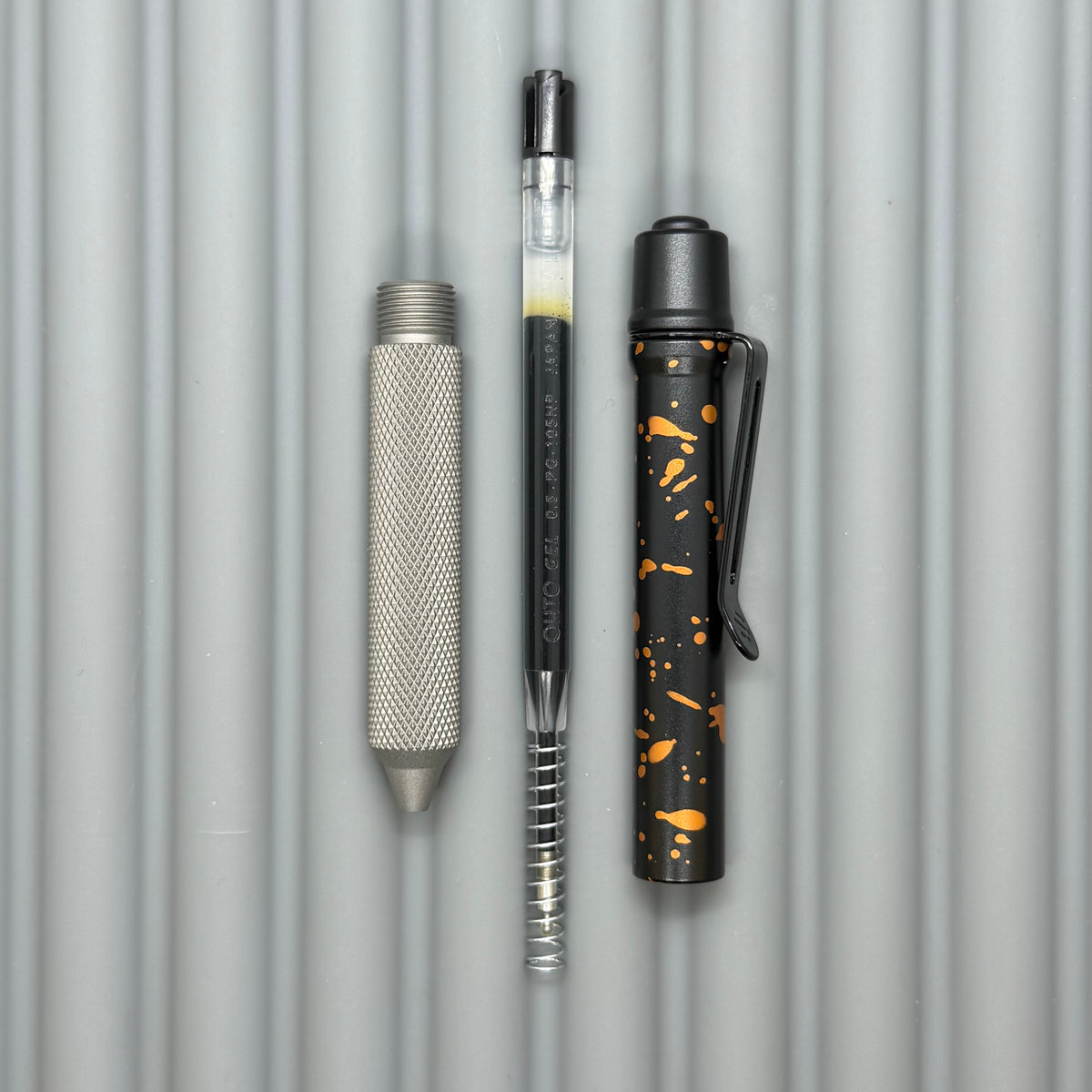 > Spoke Click Model C: Black with Orange Lava Splash, Aluminum / Matte Titanium Peak Knurled Grip